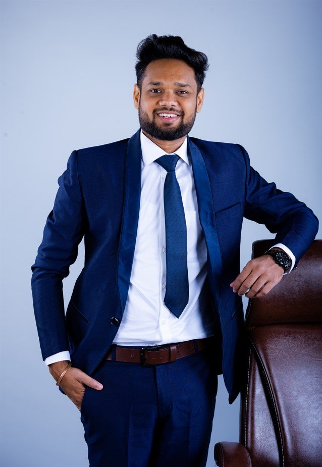 Naman Nandurkar, Founder and CEO of Octmi, wearing a suit in an office chair portrait