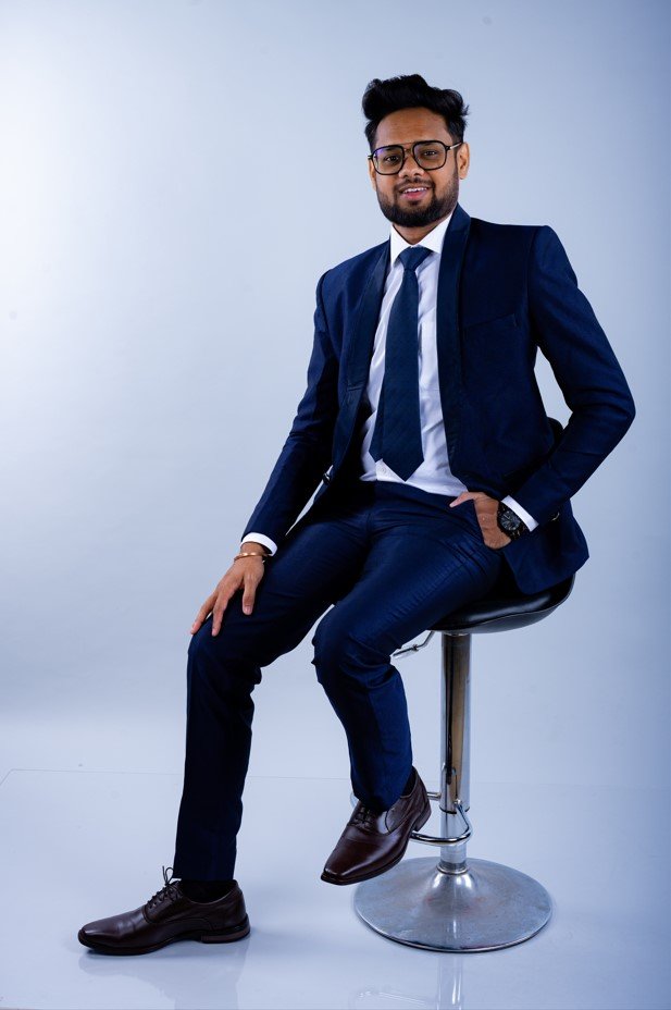 Naman Nandurkar, Founder and CEO of Octmi, seated on a tall stool in a professional portrait shoot